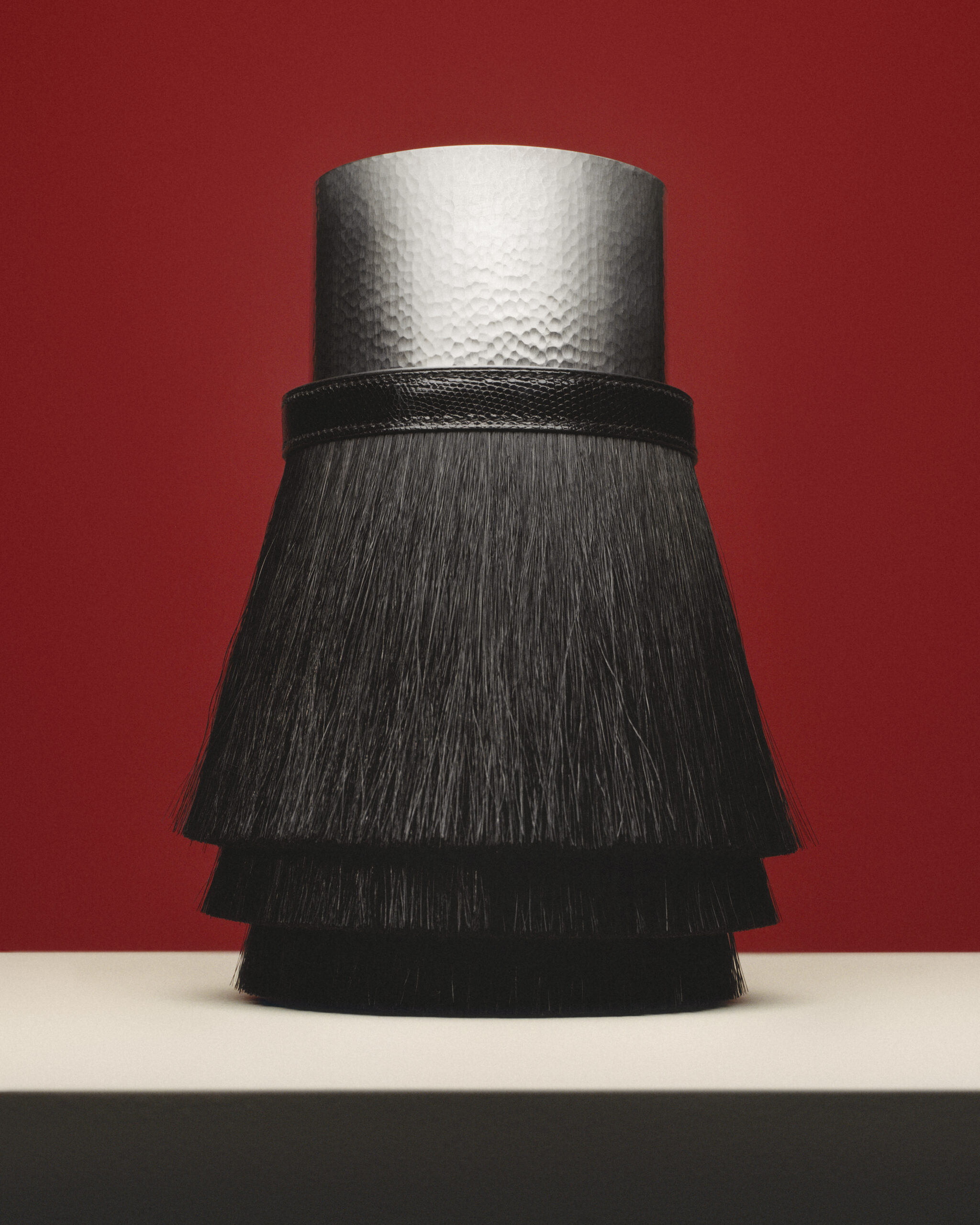 مزهرية Toupet: تباين جريء بين بريق المعدن وعمق شعر الخيل بإلهام من حقيبة أيقونية